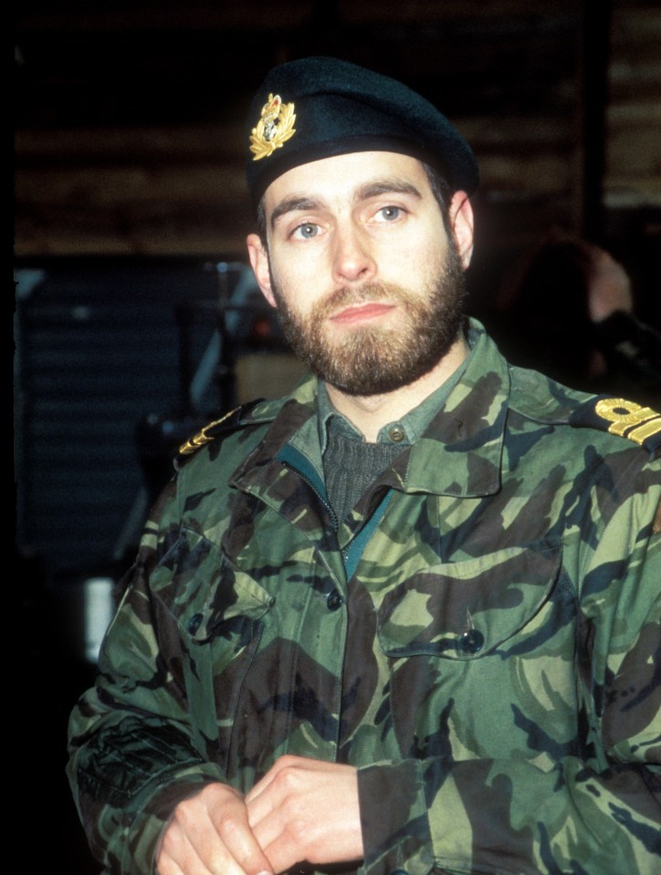 a man with a beard wears a military uniform with the letter o on the sleeve