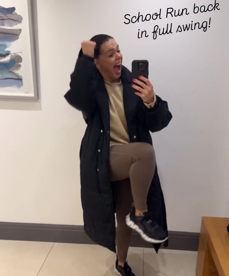 a woman taking a selfie in front of a wall that says school run back in full swing