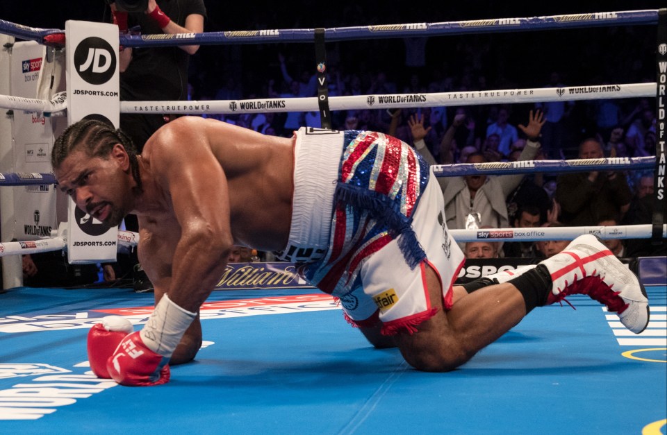 a boxer is on his knees in a boxing ring sponsored by jd sports