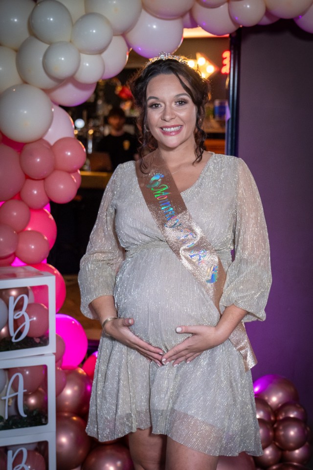 a pregnant woman wearing a sash that says baby shower