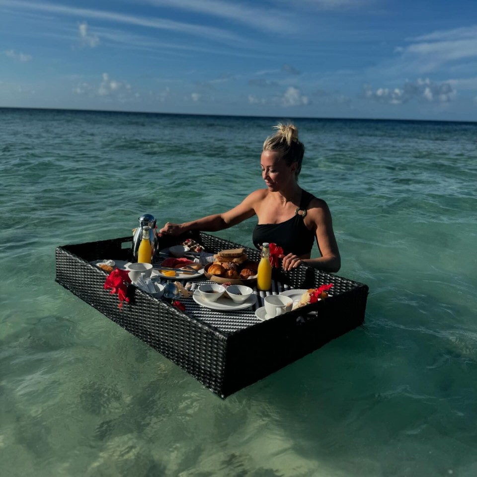 a woman is sitting on a tray of food in the ocean