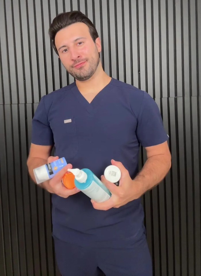 a man in a blue scrub top is holding a bottle of sunscreen