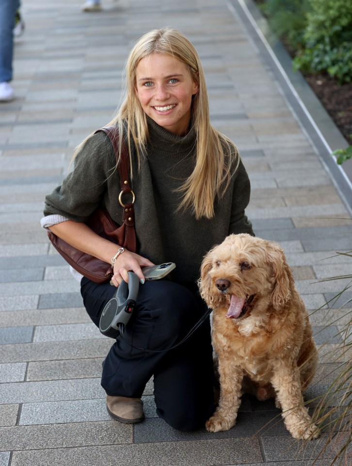 a woman kneeling down with a dog on a leash