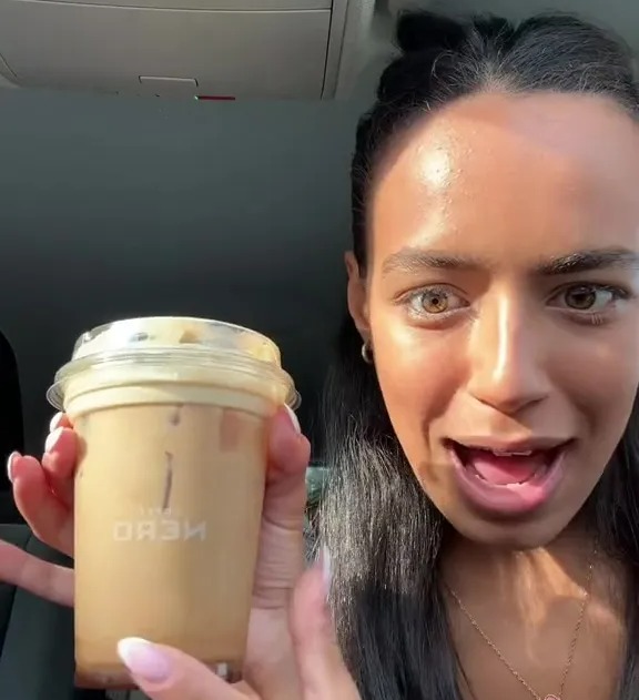 a woman is holding a cup of coffee that says dash on it