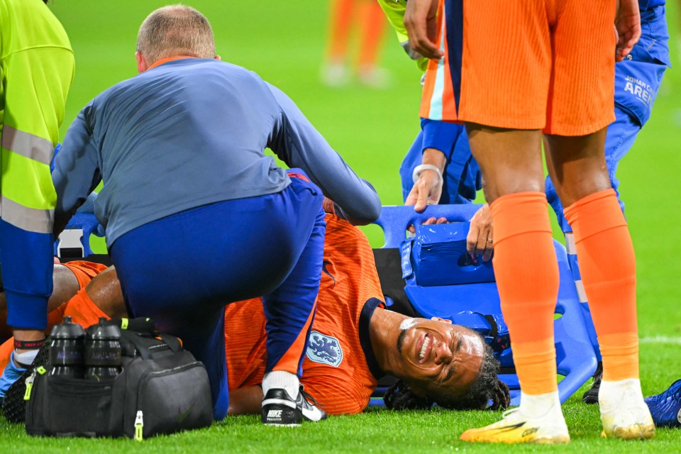 a soccer player is laying on a stretcher with the word ajax on his shorts