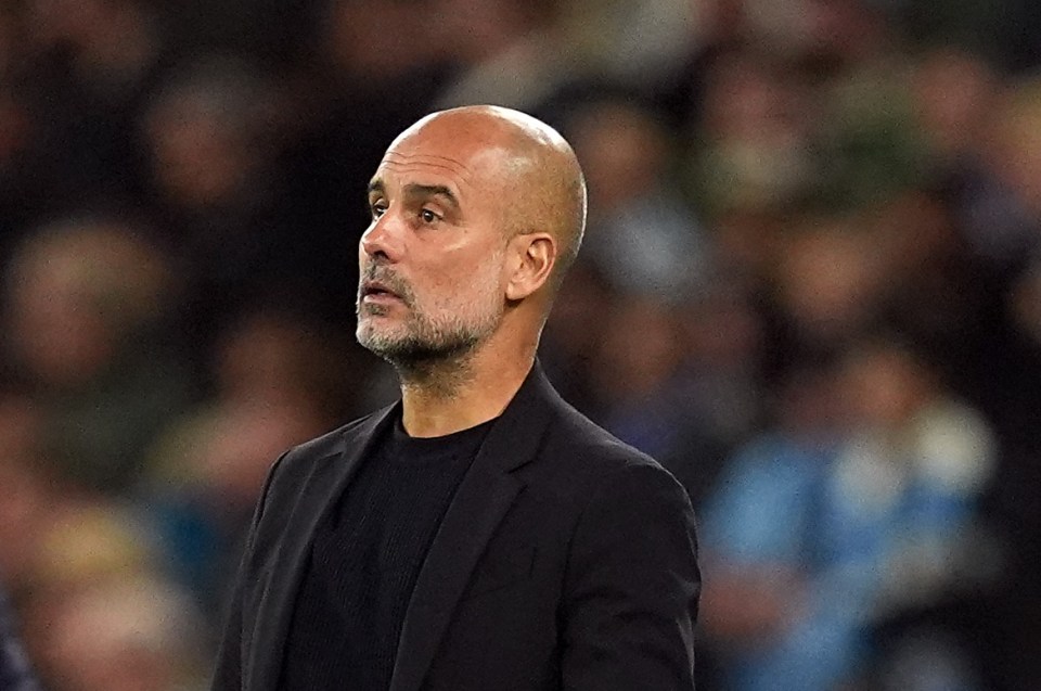 a man in a black suit stands on a soccer field