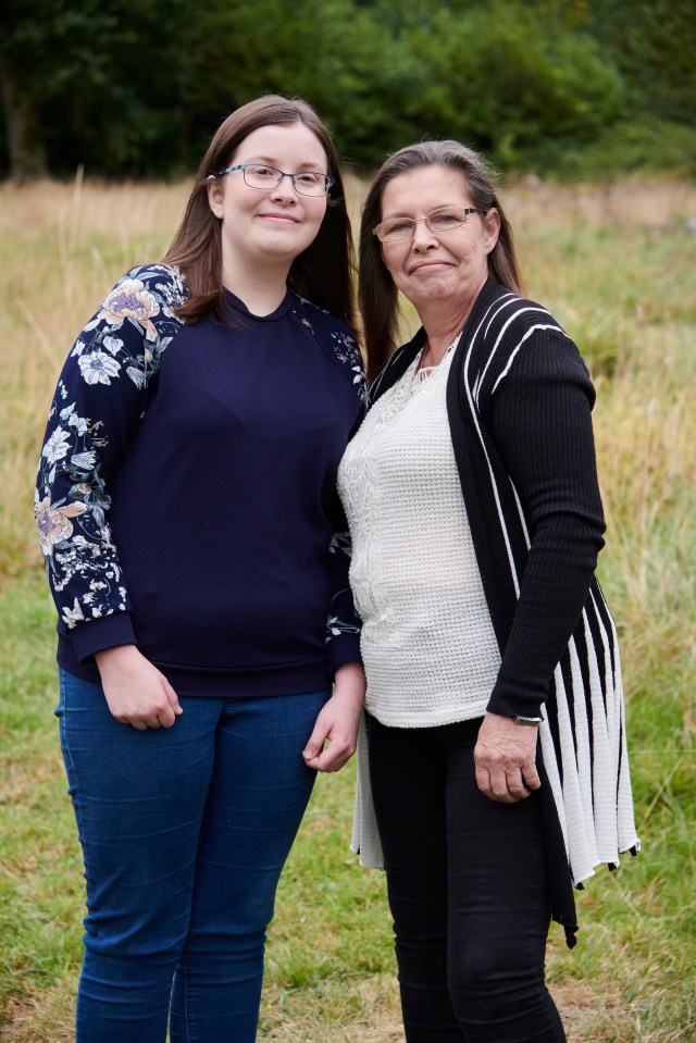 two women standing next to each other in a field