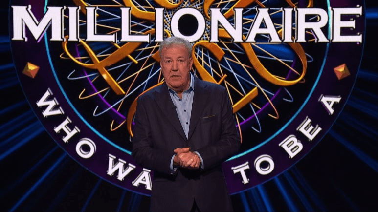 a man stands in front of a millionaire logo