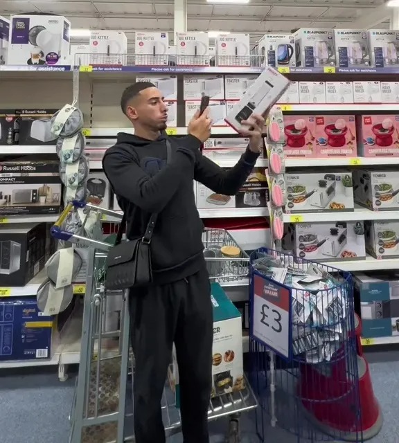 a man standing in a store with a sign that says 3 on it