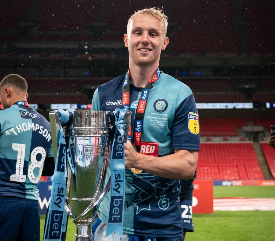 a man holding a trophy with sky bet written on it