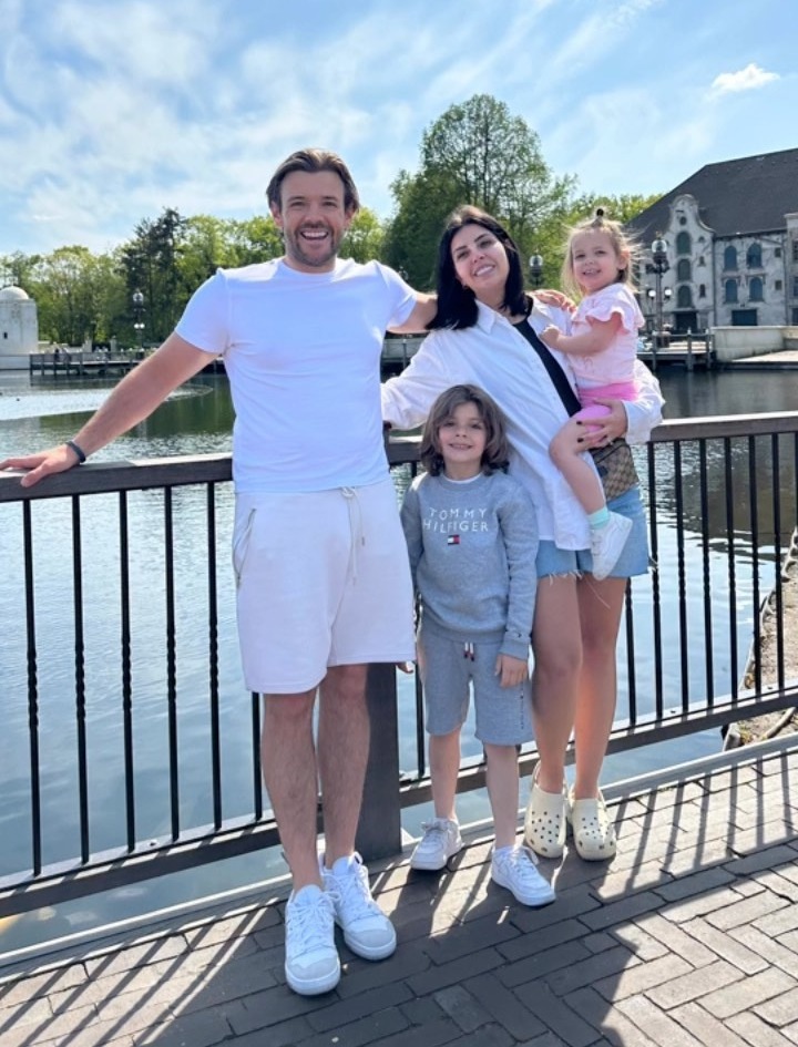 a family posing for a picture with one child wearing a tommy hilfiger sweatshirt