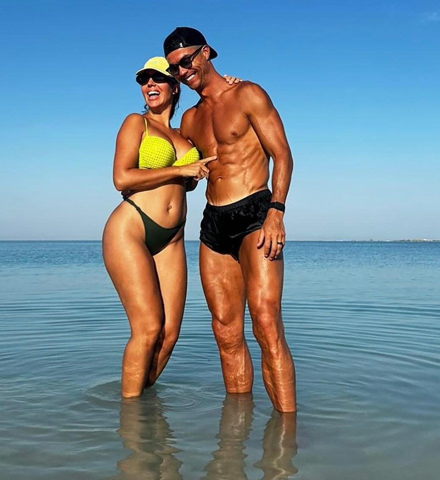 a man and a woman are posing for a picture in the ocean