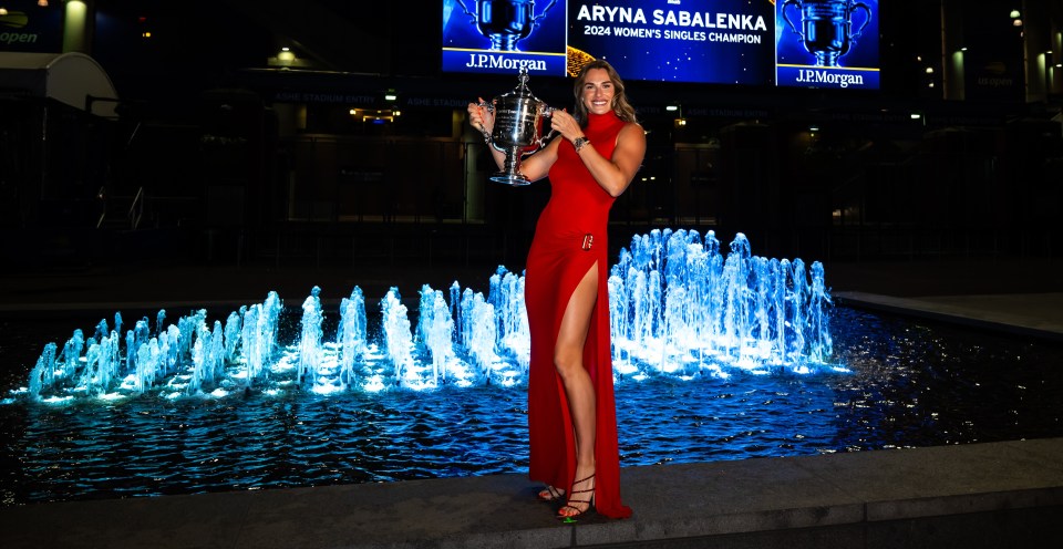 Aryna Sabalenka posed with her US Open trophy in a red dress