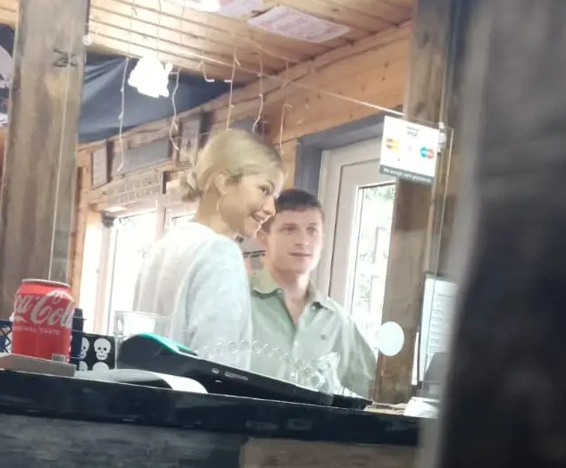 a man and a woman are behind a counter in a restaurant