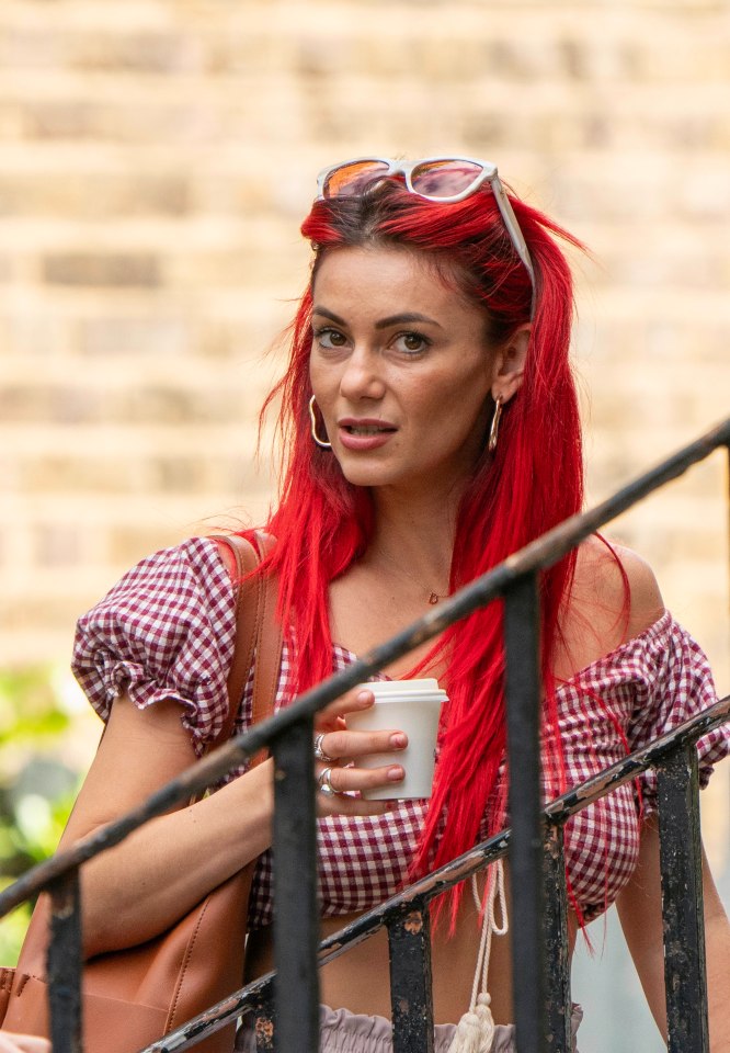 a woman with red hair is holding a cup of coffee