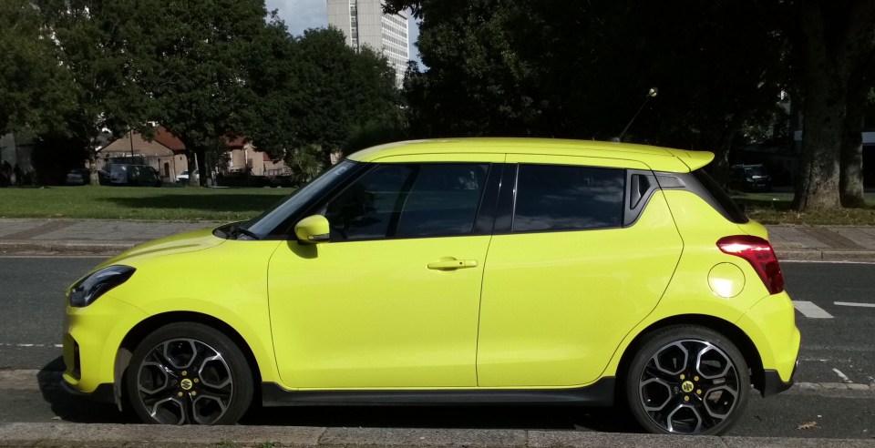 a yellow car is parked on the side of the road