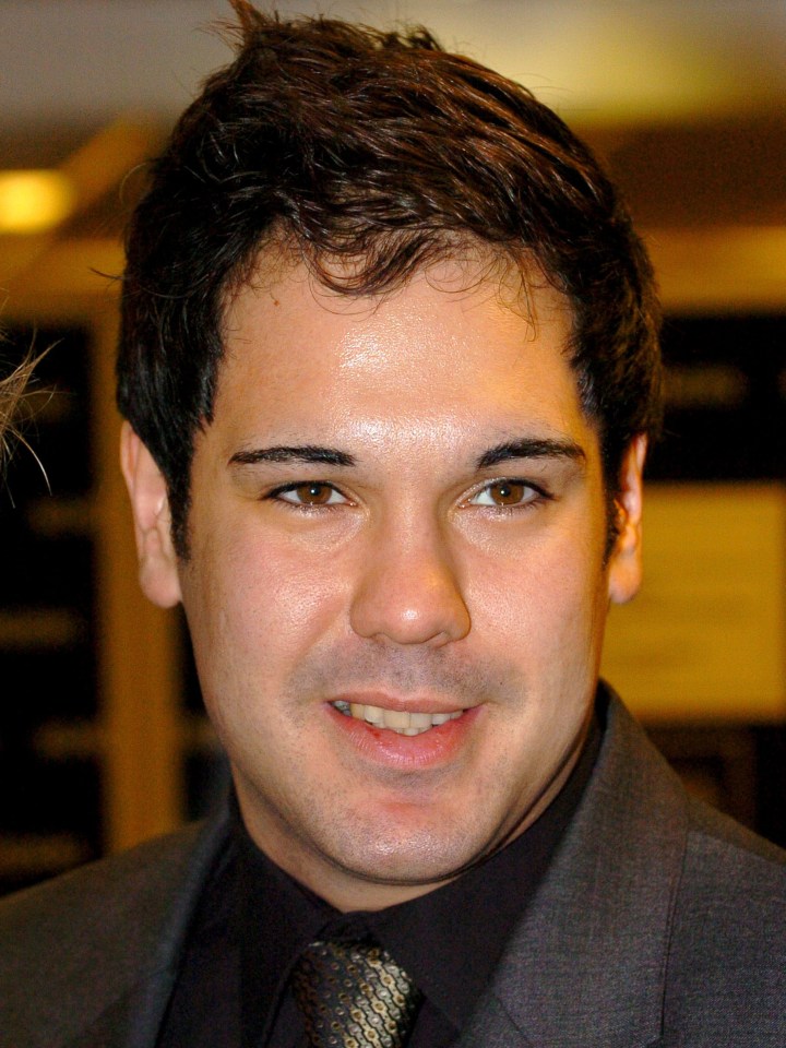 a man in a suit and tie smiles for the camera