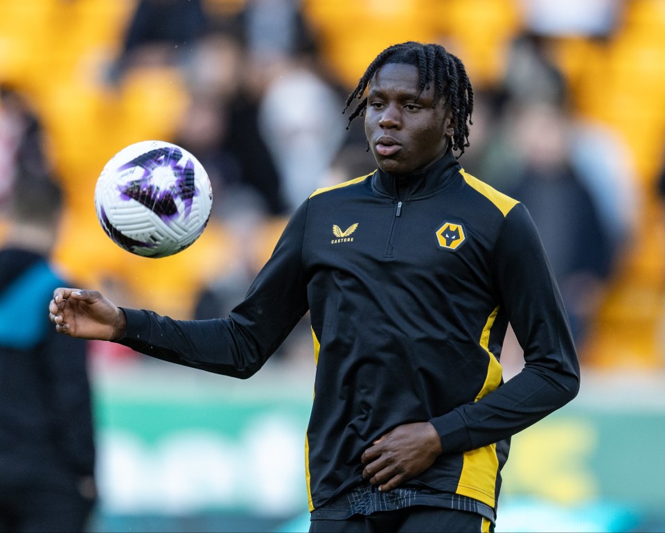 a soccer player wearing a black and yellow jacket with a wolf logo on it