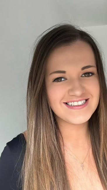 a woman with long hair and braces is smiling for the camera .