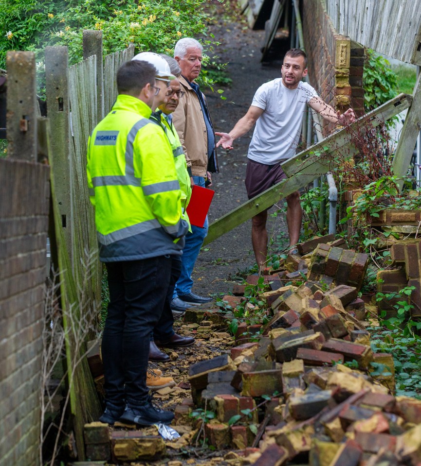 Sohail Shahin (white t shirt) talks to council official as he stands on the footpath