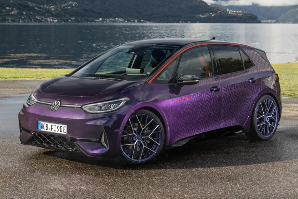 a purple volkswagen is parked in front of a lake