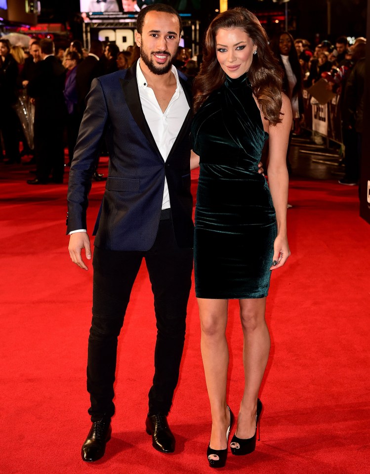 a man and a woman are standing on a red carpet