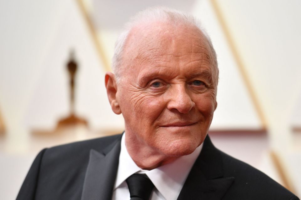 an older man in a suit and tie smiles for the camera