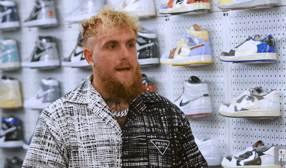 a man in a prada shirt stands in front of a wall of sneakers