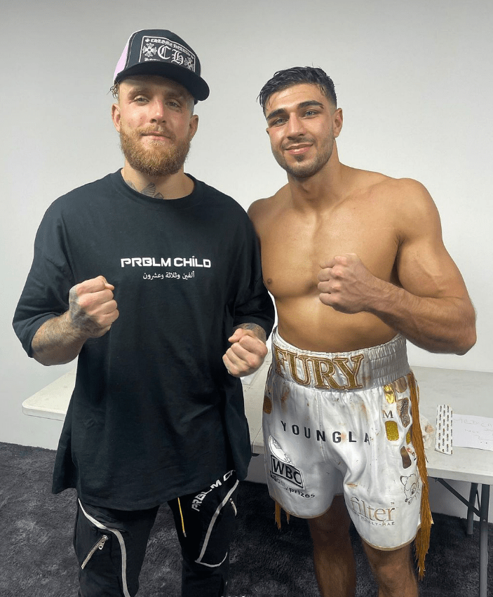 two men posing for a picture one wearing a shirt that says prolm child