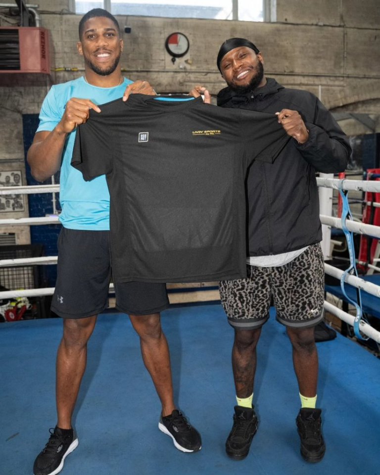 two men holding up a black shirt that says low waist