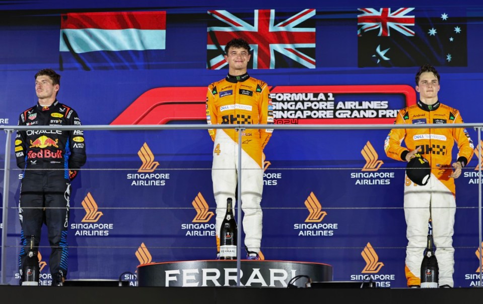 SINGAPORE, SINGAPORE - SEPTEMBER 22: Max Verstappen of the Netherlands and Oracle Red Bull Racing, Lando Norris of Great Britain and McLaren F1 Team and Oscar Piastri of Australia and McLaren F1 Team on the podium during the F1 Grand Prix of Singapore at Marina Bay Street Circuit on September 22, 2024 in Singapore, Singapore. (Photo by Qian Jun/MB Media/Getty Images)