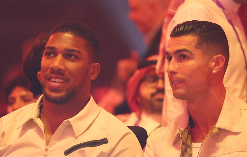 RIYADH, SAUDI ARABIA - MAY 18: Anthony Joshua, English heavyweight boxer, and Cristiano Ronaldo, Portuguese football player watch on from ringside during the Ring Of Fire card at Kingdom Arena on May 18, 2024 in Riyadh, Saudi Arabia. (Photo by Richard Pelham/Getty Images)