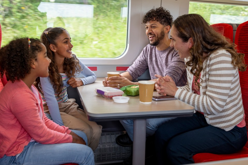 a family sits at a table on a train