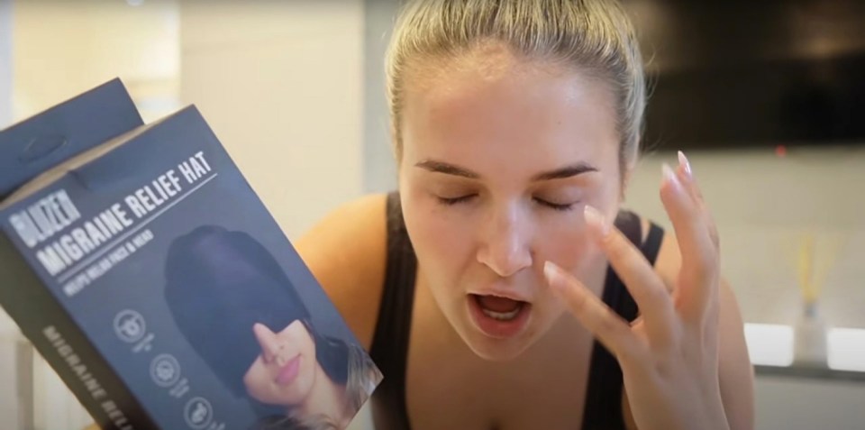 a woman is holding a box that says ' migraine relief hat ' on it