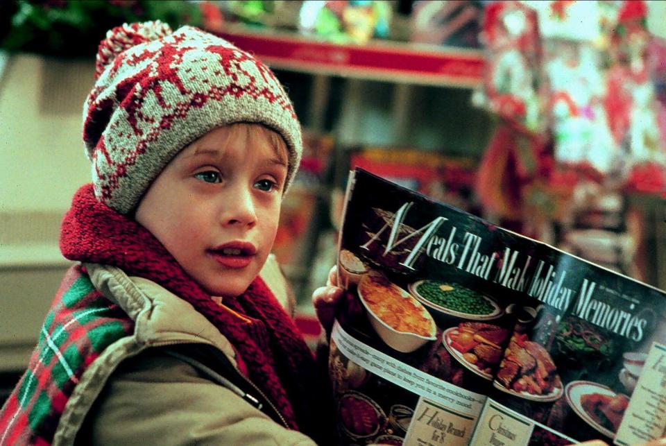 a young boy is reading a magazine about meals that make holiday memories