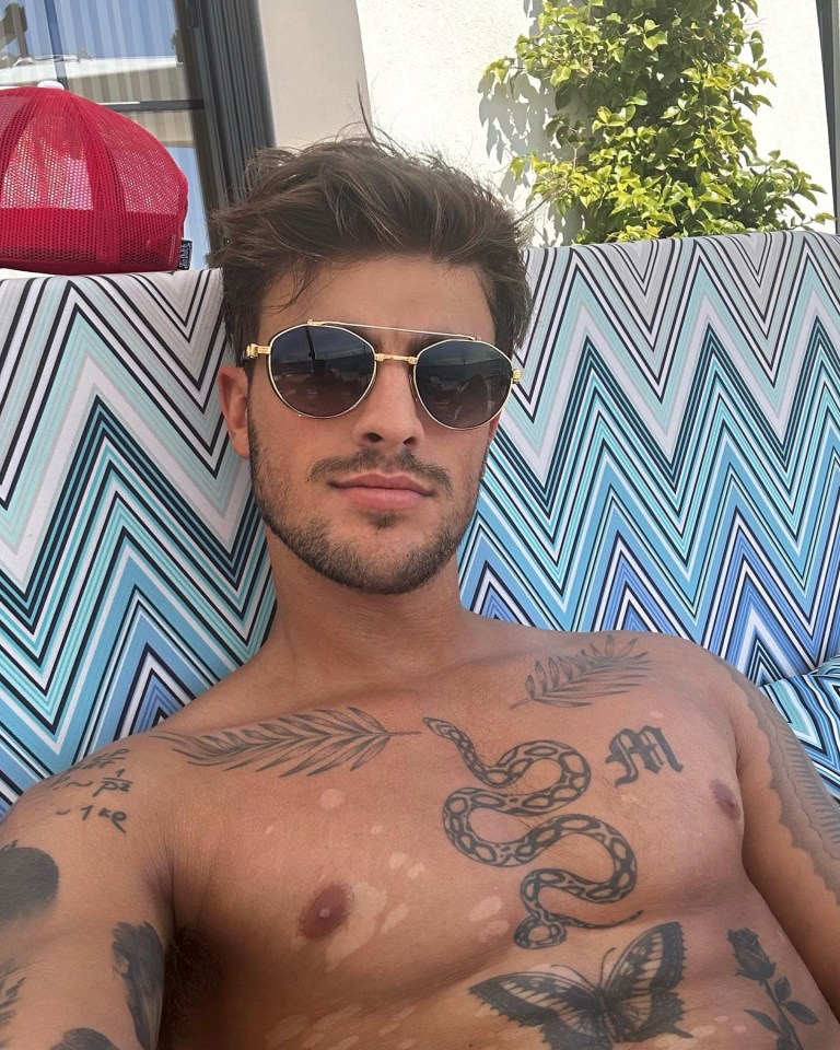 a shirtless man with a snake tattoo on his chest