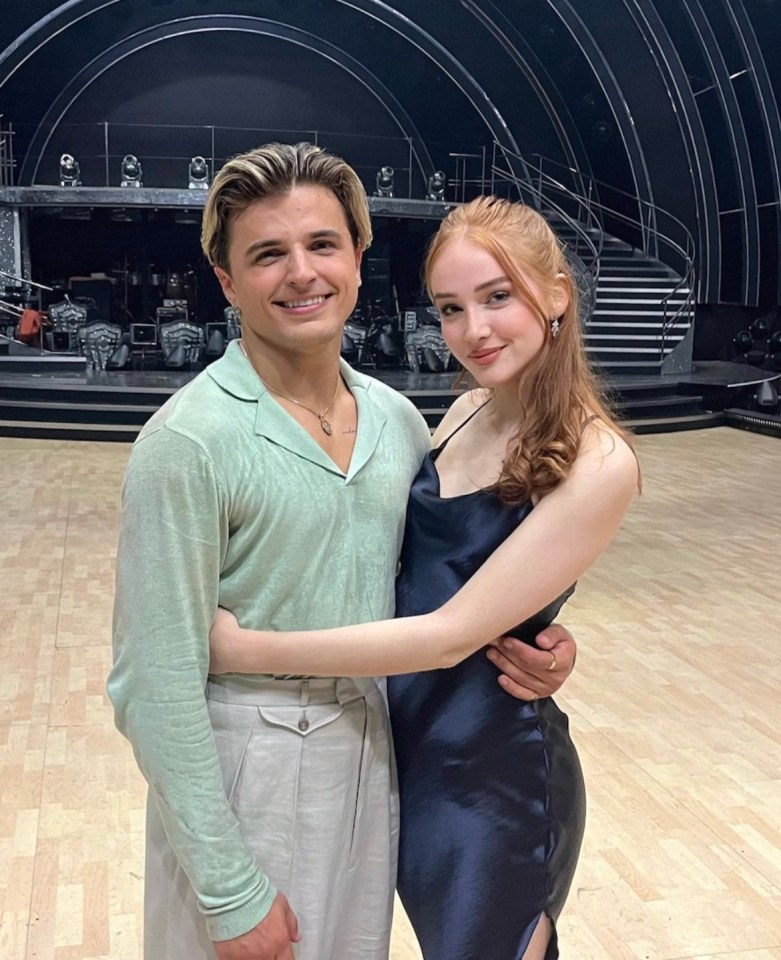 a man and a woman are posing for a picture on a dance floor