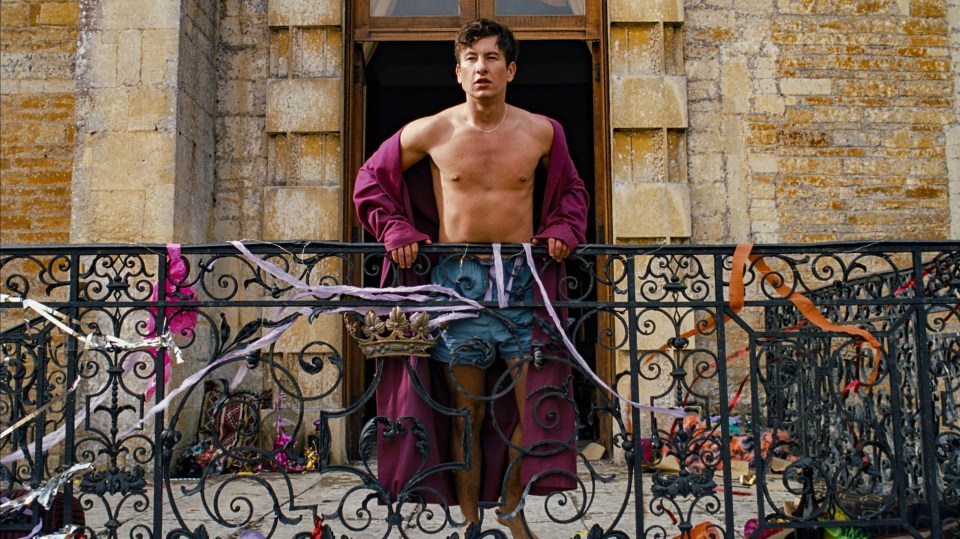 a shirtless man in a purple robe stands on a balcony