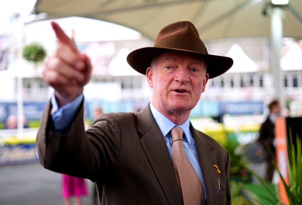 a man in a suit and hat points his finger