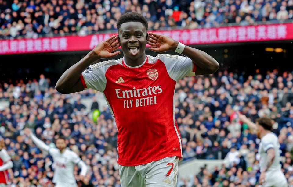 a soccer player wearing a red emirates fly better jersey