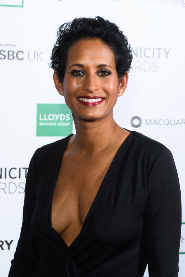 a woman in a black dress is smiling in front of a sign that says lloyds banking group