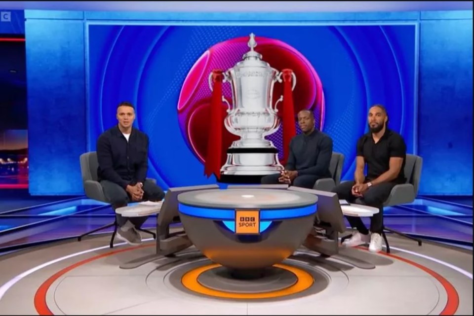 three men sit around a table with a bbc logo on it