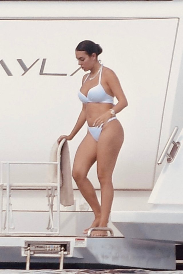 a woman in a bikini stands on the steps of a boat with the word ivyl on the side