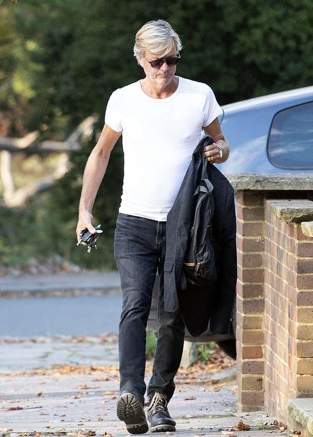 a man in a white t-shirt is walking down the street