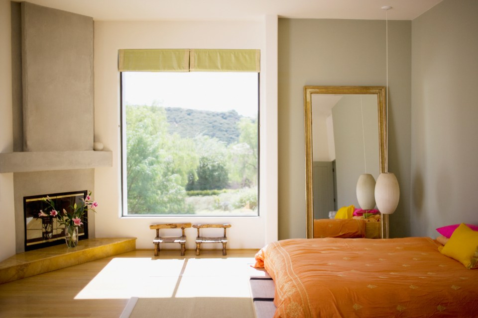 a bedroom with a large mirror and a fireplace