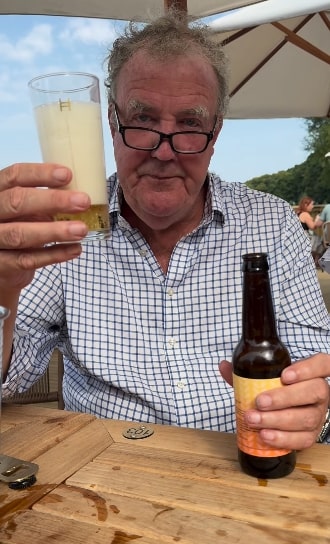 a man is holding a glass of beer and a bottle of beer