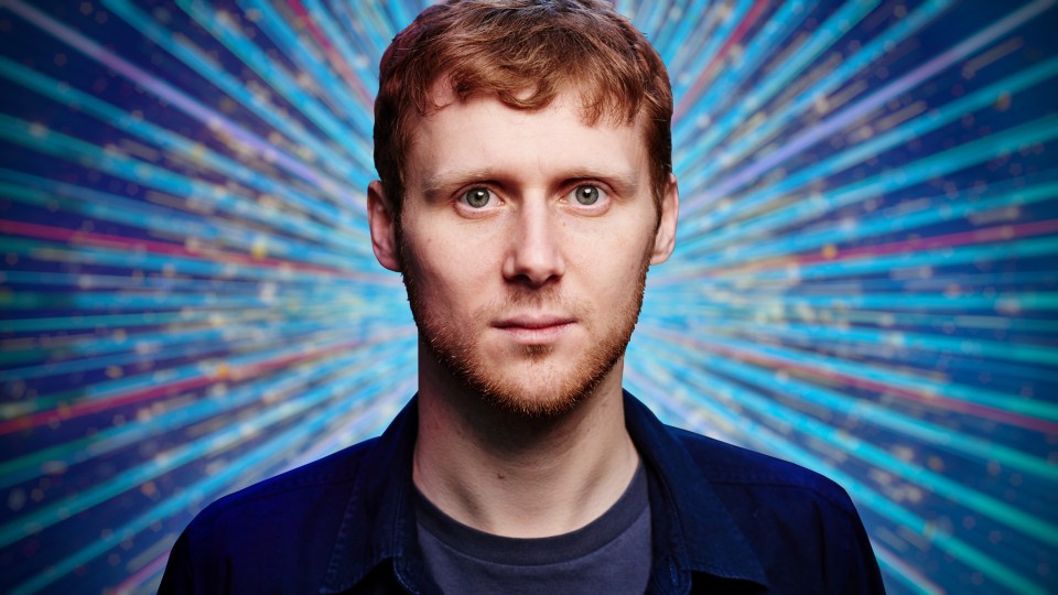 a man with a beard stands in front of a blue background