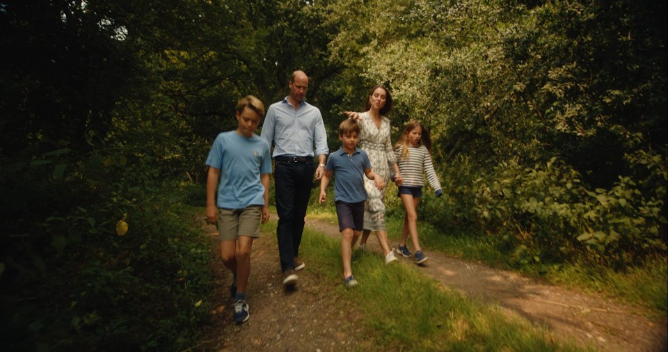 a family walking down a path in the woods