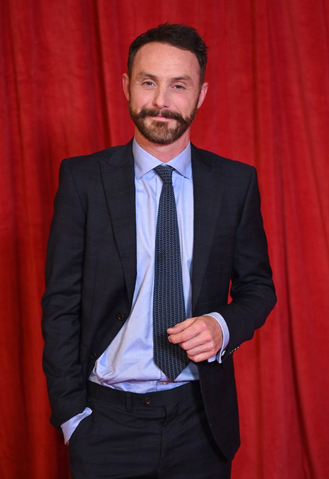 a man in a suit and tie with his hands in his pockets