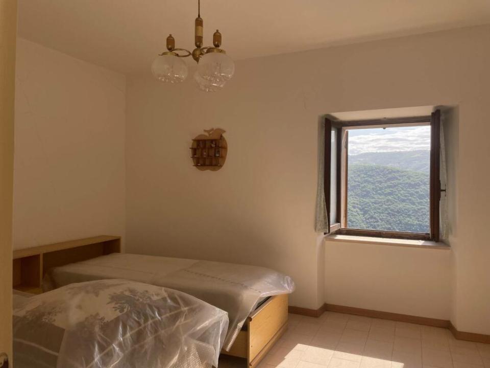 a bedroom with two beds and a window with mountains in the background